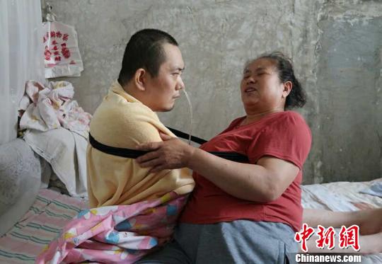 身體日漸衰老的梁青蘭每次幫兒子翻身、坐立，全身的衣物都要濕透一次?！∩忻鱾b 攝