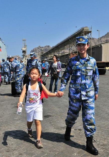 2015年3月，也門，海軍女戰(zhàn)士牽著一名小女孩的手準備登上軍艦。