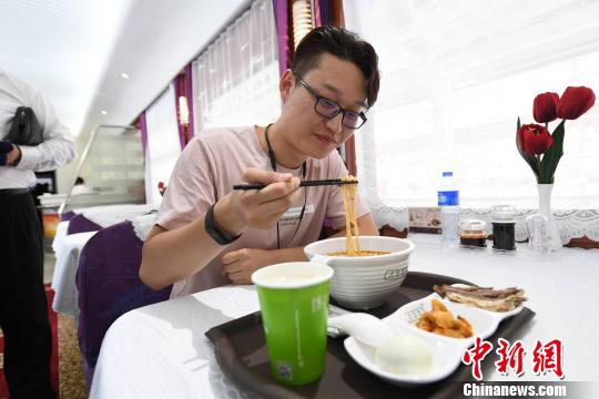 圖為旅客在列車上享用正宗牛肉面?！钇G敏 攝