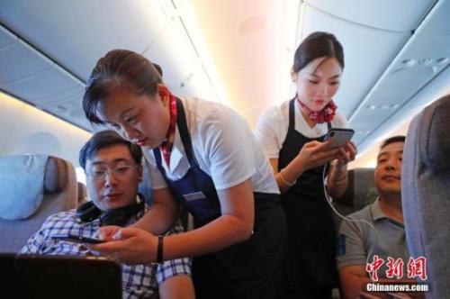 資料圖：乘務(wù)員們?cè)诳团搩?nèi)為旅客調(diào)試機(jī)上上網(wǎng)功能。<a target='_blank' ><p  align=