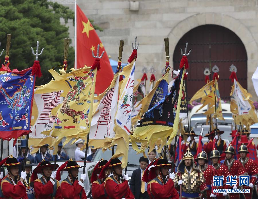 7月3日，韓國總統(tǒng)樸槿惠在青瓦臺總統(tǒng)府舉行隆重儀式，歡迎中國國家主席習(xí)近平對韓國進行國事訪問。這是習(xí)近平的車隊在身著民族服裝的韓國禮儀隊伍引導(dǎo)下駛?cè)肭嗤吲_。新華社記者丁林?jǐn)z  